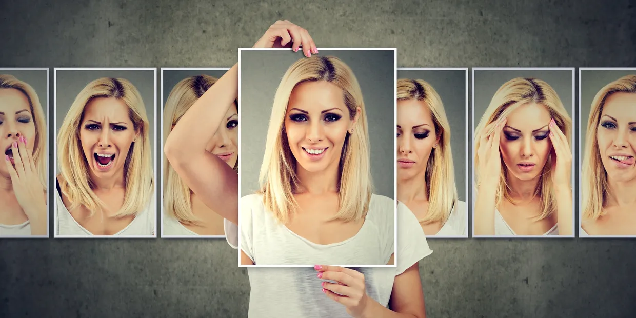 A woman holding up a picture of herself.