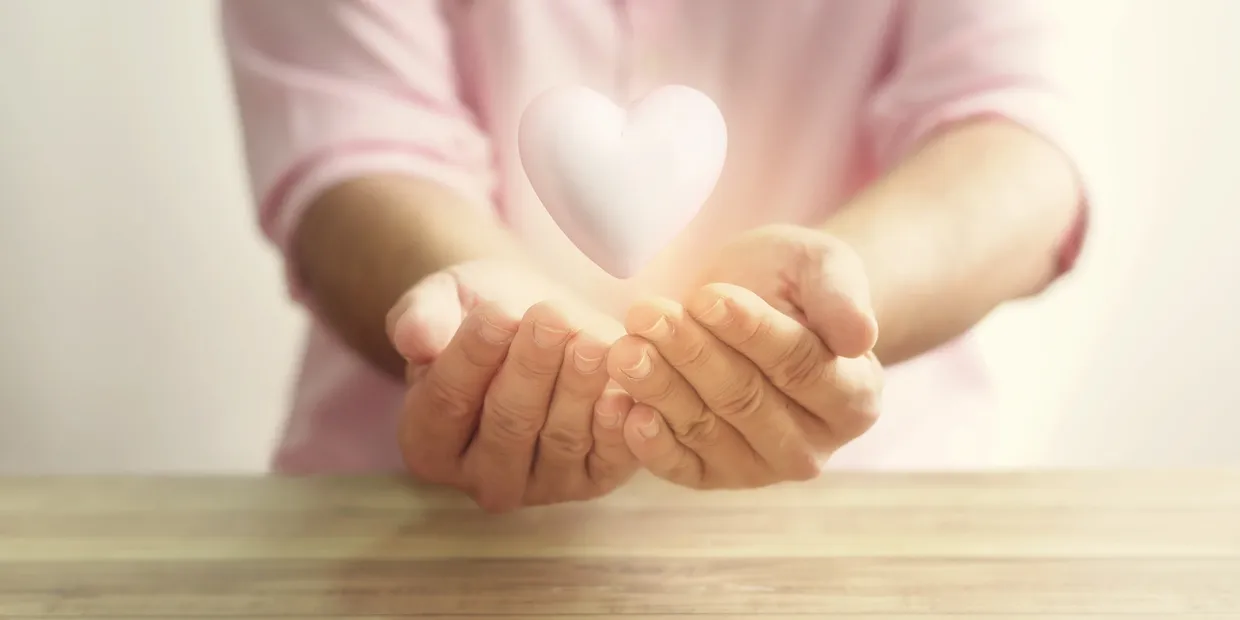 A person holding their hands open with a heart in the middle.