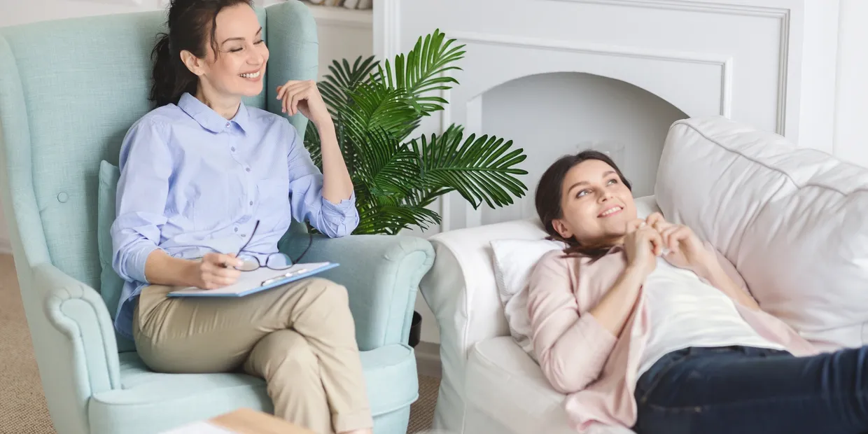 A woman sitting in front of another person.