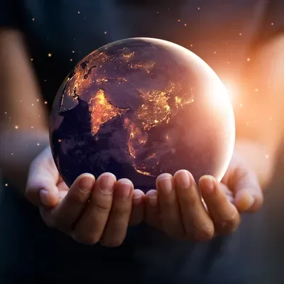 A person holding an earth globe in their hands.